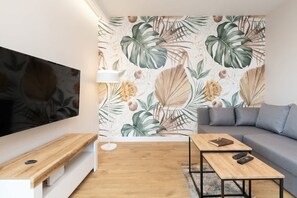 The elegant living room featuring a double sofa bed, perfect for relaxing or sleeping.