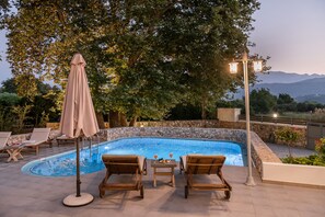 Modern sunbeds and parasols at the pool area.