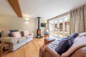 The Barn, Great Ryburgh: Sitting room with wood burning stove and doors to the garden