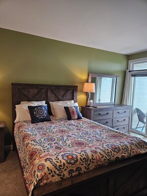 Primary bdrm: queen bed, en suite bathroom to the left, balcony to the right.