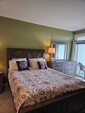 Primary bdrm: queen bed, en suite bathroom to the left, balcony to the right.