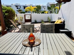 sunny terrace with sunbeds and dining table