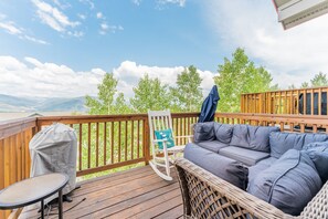 Balcony off the living area offers breathtaking views, comfortable furniture, and a grill.