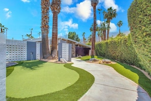 Putting green with putters and golf balls for your use