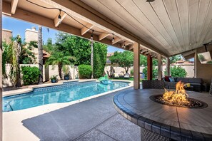 Outdoor dining table and fire pit, poolside.