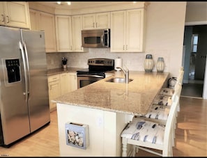Kitchen - with stainless steel appliances and granite countertops.   