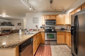 Updated fully equipped kitchen with breakfast bar that overlooks living and dining