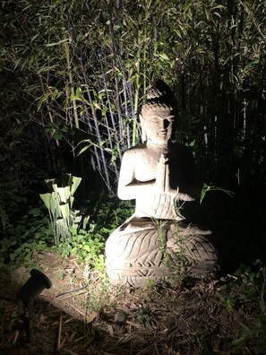 Bouddha sculpté en pierre de lave en salutation