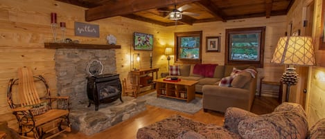 Cozy Living Room with Gas Buck Stove, HD Smart TV, Exposed Beams, and Comfy Furniture