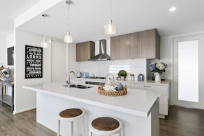 Prepare meals with ease in the stylish kitchen featuring top-notch appliances and stone bench tops