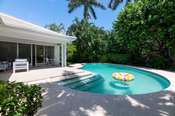 The pool is heated by request and a well-manicured and lush tropical lawn sits to the right of the pool.