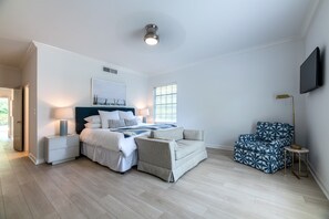 The Master features a King bed with an upholstered royal blue headboard and a small loveseat sofa at the foot of the bed. The rooms has furnishings with accents of blues, whites and gold. The spacious bedroom has loads of closet space