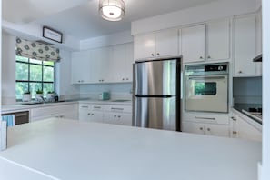 The impressive pure white Retro- style kitchen is complete with a new stainless steel fridge and a timeless "old school" stove top and oven. Funky Retro themed microwave and toaster bring it all together.