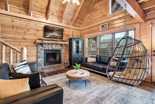 Comfortable leather couches + a swing chair give the perfect space for hanging