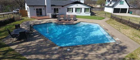 Pool with basketball, putting green, grill and outdoor bar with fridge.

