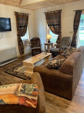 Living room area with all brand new furniture, 2 comfy gliders, a couch.