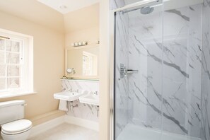 The Scott Apartment - the apartment's bathroom features a large walk-in shower with rainfall showerhead and a freestanding slipper bath