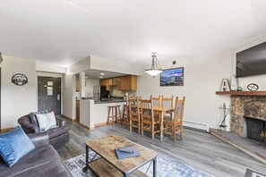 large dining and living area with wood-burning fireplace and large HDTV