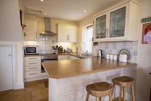 Winsbury Cottage, East Hauxwell: Kitchen featuring breakfast bar with seating