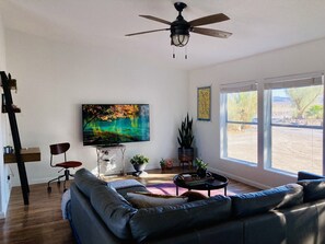 Living room features a 65 in Samsung smart TV and dedicated work space. 