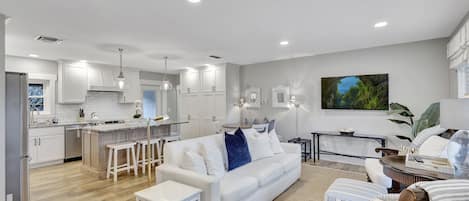 Open concept living room with seating area and dining table. 