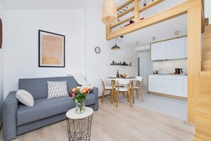The same room, highlighting the sofa and decor, with natural light streaming through a skylight.
