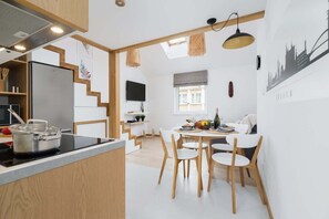 A wooden staircase leading to the loft, situated in a cozy living area with minimalistic decor.