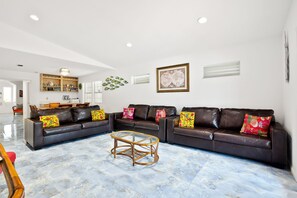 Ground floor living room with ample seating and a flat screen TV.