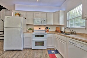 Full kitchen with stove, oven, refrigerator, microwave, and sink