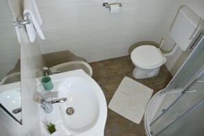 Das Badezimmer mit Dusche, WC, Bidet, Waschbecken mit Spiegel