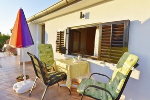 The terrace equipped with a garden table and chairs, umbrella.