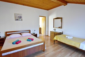 The bedroom with double and single bed, a chest of drawers and a mirror.