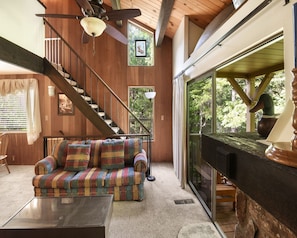 Living room with Smart TV, wood burning fireplace, and balcony access