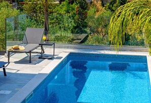 Blick auf den großen Swimmingpool mit Sonnenliegen zum Ausruhen und Entspannen in der berühmten Luxusvilla Raquel, umgeben von viel Grün auf der Insel Šolta