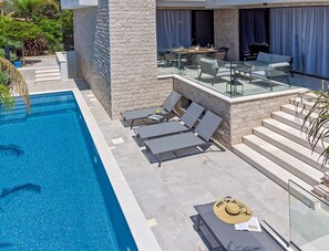 Private sunbathing area next to the swimming pool of the beach front  villa Raquel in Šolta with a lounge area for rest and dining