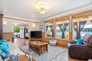 Living room with gas fireplace, TV and view of the bay.