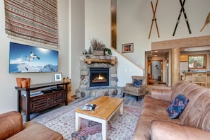 Living Room with floor to ceiling windows, gas fireplace, 58" Samsung Smart Tv, plush leather furnishings with sofa sleeper, and private balcony access