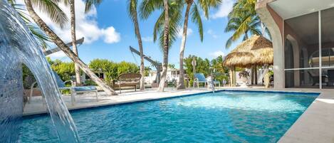 Indulge in the beauty of your pool adorned with a tranquil waterfall, while overlooking the picturesque canal.