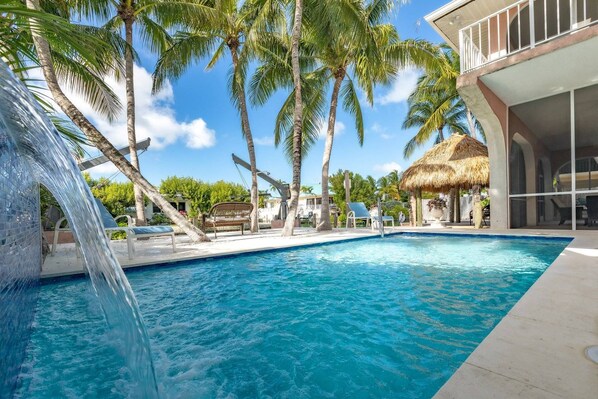 Indulge in the beauty of your pool adorned with a tranquil waterfall, while overlooking the picturesque canal.