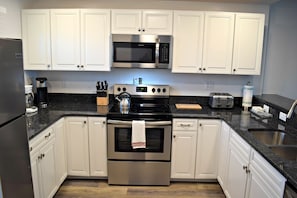 Tile floors, granite counter tops, and new cabinets in this kitchen.