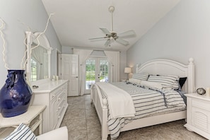 Master bedroom with en-suite bathroom and French doors leading to the pool area.