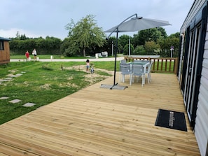 La grande terrasse en bois est surélevée de trois marches