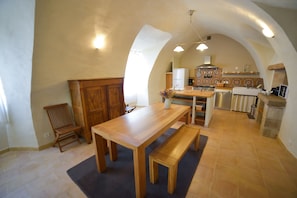 Une salle à manger avec îlot centrale et cuisine aménagée 