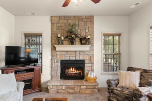 The living room has seating for everyone to enjoy the electric fireplace.