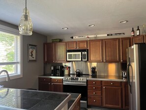 Stocked kitchen with electric stove and built in air fryer over