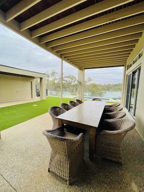 Outdoor alfresco living with outdoor kitchen behind secure roller door.