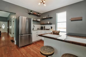 Updated Kitchen with quartz and butcher block counter tops, open shelving and large walk-in pantry