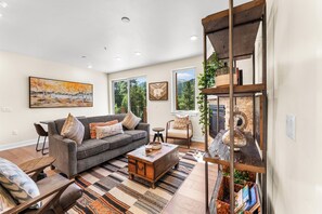Cozy living area with ample seating, gas fireplace, flatscreen tv, and children&#39;s games/books provided.