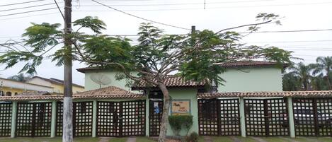 Visão da entrada do condomínio. Estacionamento interno com portões individuais.