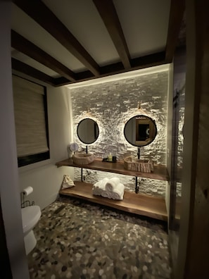 Dual sinks made of real petrified wood give a custom touch to master bathroom